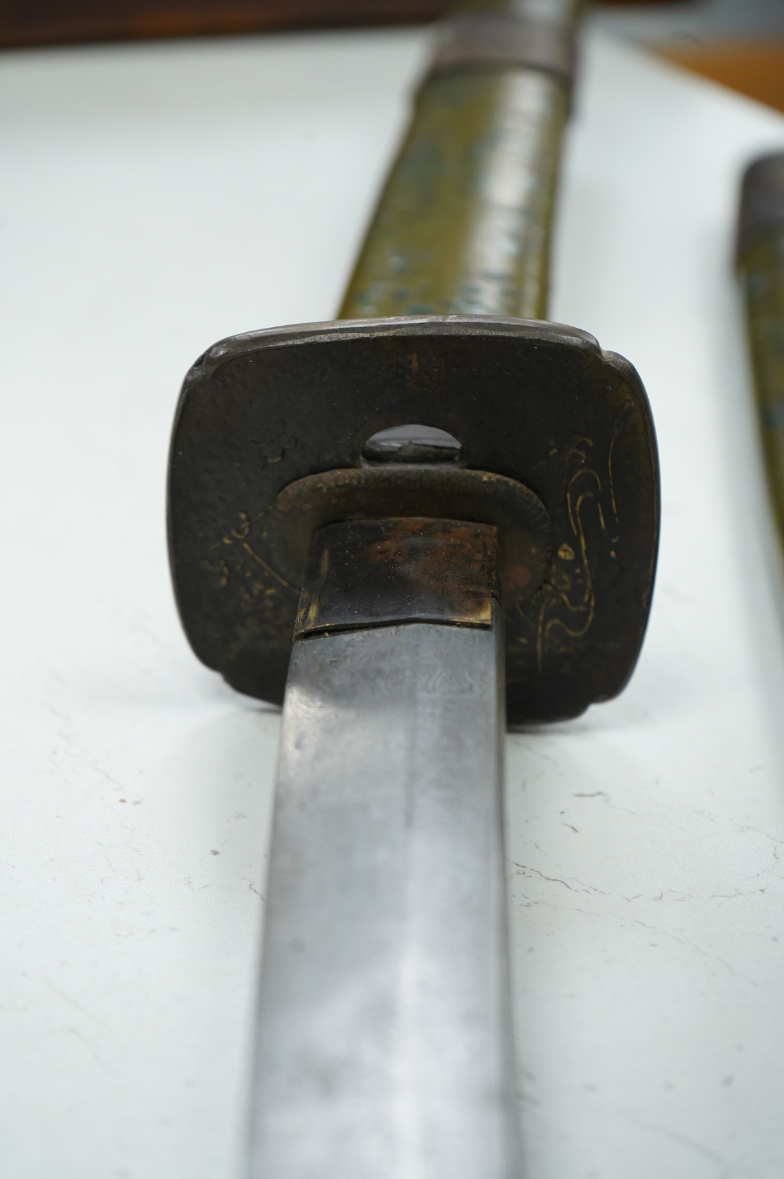 A well-made Chinese copy of a Japanese sword katana, blade etched with wood grain imitation, green painted handle, scabbard with engraved brass mounts